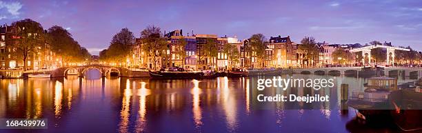 illuminated amsterdam canal bridges at night holland - amsterdam skyline stockfoto's en -beelden