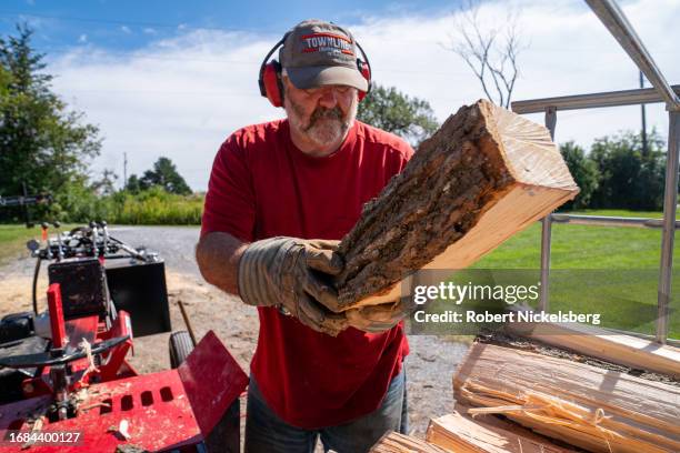 Pat Leclaire moves a piece of ash hardwood into a metal basket making firewood for his sugaring operation September 15, 2023 in Charlotte, Vermont....