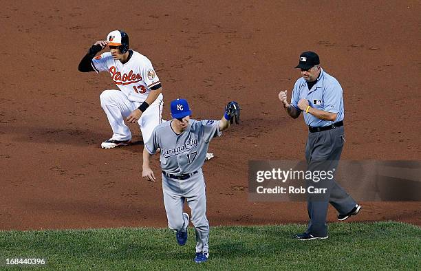 Umpire Dale Scott makes the call as Chris Getz of the Kansas City Royals holds up the ball after tagging out Manny Machado of the Baltimore Orioles...