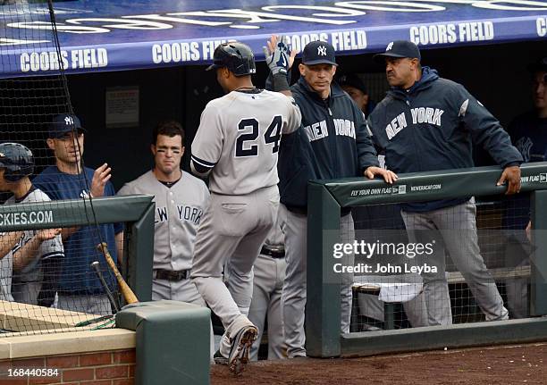 Robinson Cano of the New York Yankees high fives manager Joe Girardi after his home run in the fifth inning off of Adam Ottavino of the Colorado...