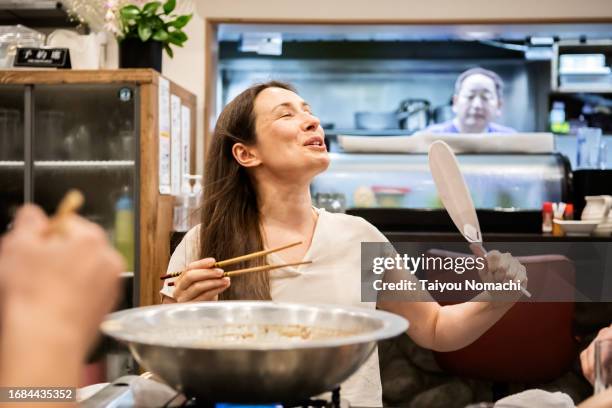 tourists from overseas cool off using ``uchiwa'' at a japanese izakaya. - voyage expérientiel photos et images de collection