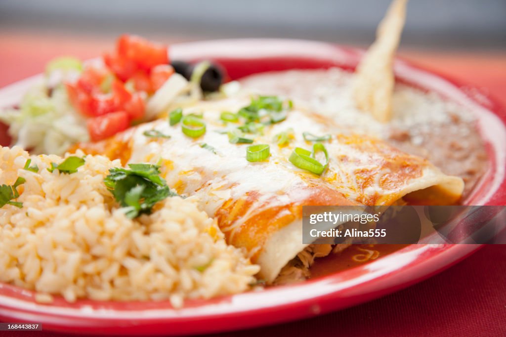 Mexican food: plate with beef enchiladas, rice and refried beans