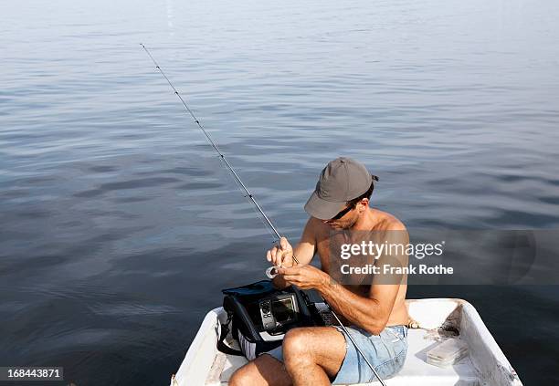 man fishing from a boat at a big lake - angelausrüstung stock-fotos und bilder