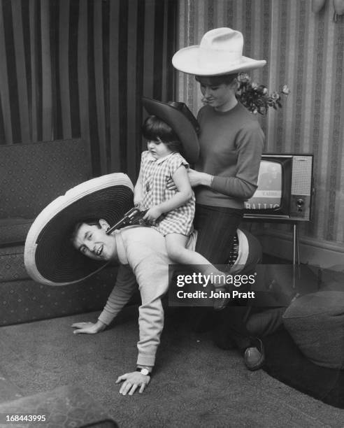 English comedian Jimmy Tarbuck gives a ride to his daughter, Cheryl, and wife Pauline, at their home in Liverpool, November 1963.