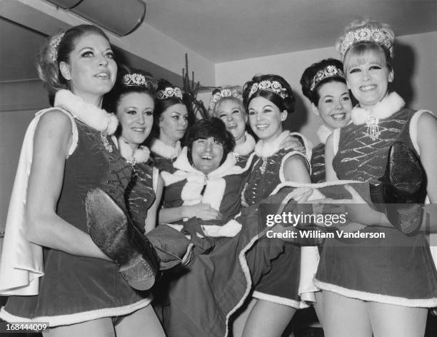 English comedian Jimmy Tarbuck is carried by a troupe of 'Miss Christmasses' at a Variety Club of Great Britain charity lunch at the Savoy Hotel,...