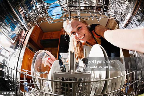 seen from inside drum, pretty blonde loads the dishwasher - dishwasher stock pictures, royalty-free photos & images