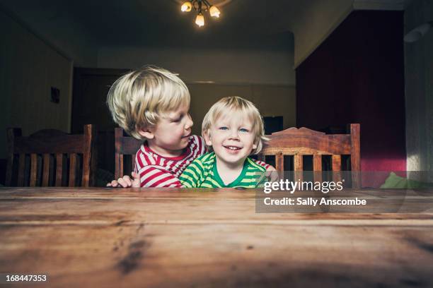 two happy little brothers - holztisch stock-fotos und bilder