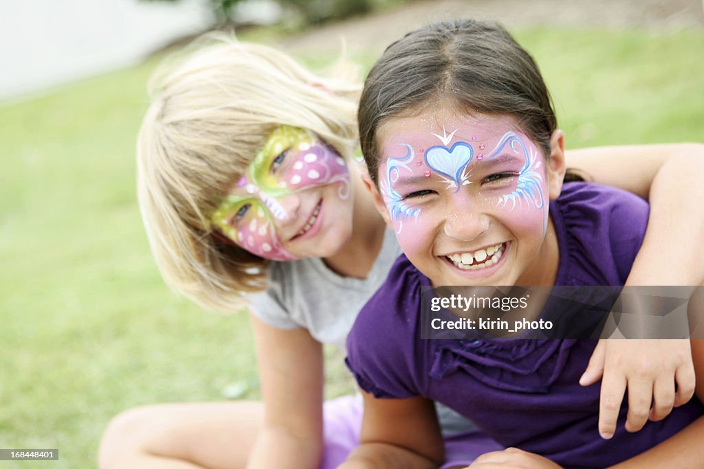 Happy kids with painted faces wearing purple
