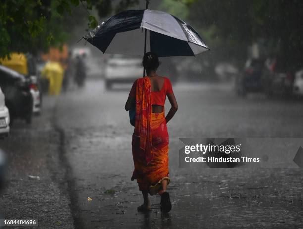 Commuters seen out during rain at Sector 12 road, on September 23, 2023 in Noida, India.