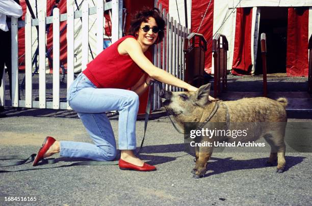 Anna Maria Kaufmann, kanadisch-deutsche Musical- und Opernsängerin, vor einem Zirkuszelt mit einem Schwein.