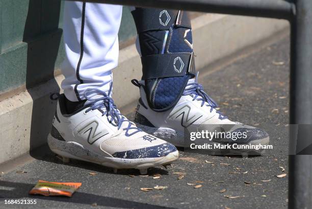 Detailed view of the custom New Balance baseball shoes worn by Spencer Torkelson of the Detroit Tigers as he stands in the dugout during the game...