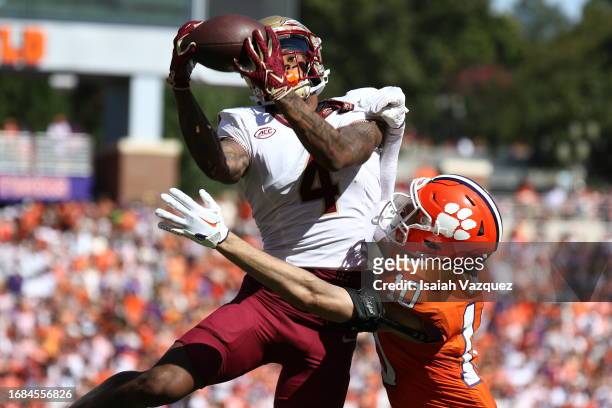 Keon Coleman of the Florida State Seminoles makes the game-winning catch against Jeadyn Lukus of the Clemson Tigers in overtime at Memorial Stadium...