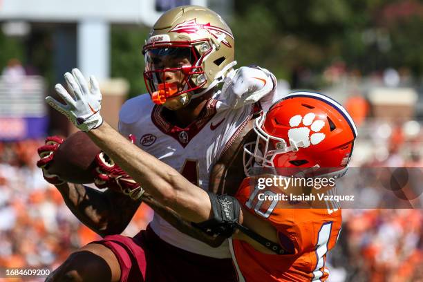 Keon Coleman of the Florida State Seminoles makes the game-winning catch against Jeadyn Lukus of the Clemson Tigers in overtime at Memorial Stadium...