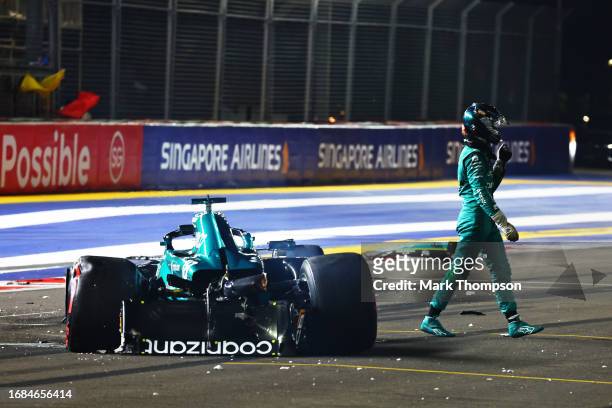 Lance Stroll of Canada and Aston Martin F1 Team walks across the track after crashing on track during qualifying ahead of the F1 Grand Prix of...