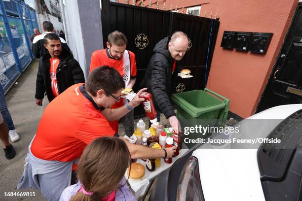 Fans reach for the condiments during the Premier League match between Luton Town and Wolverhampton Wanderers at Kenilworth Road on September 23, 2023...