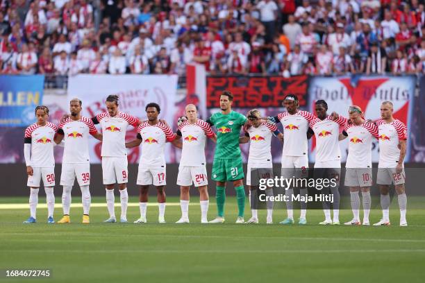 Players, Match officials and fans take part in a minute's silence for the victims of the Morocco earthquake prior to the Bundesliga match between RB...