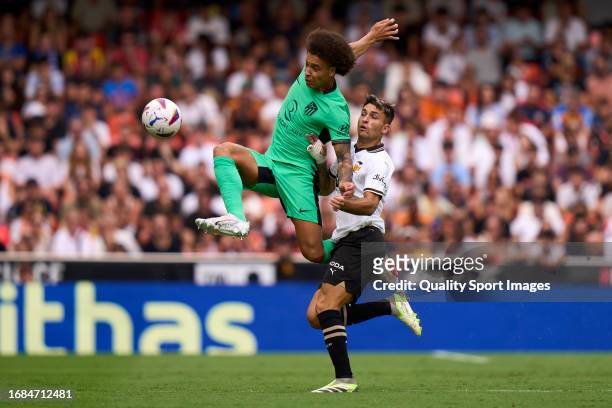 Hugo Duro of Valencia CF battle for the ball with Axel Witsel of Atletico de Madrid during the LaLiga EA Sports match between Valencia CF and...