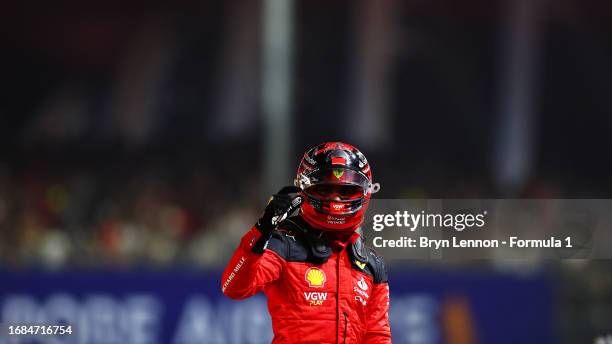 Pole position qualifier Carlos Sainz of Spain and Ferrari celebrates in parc ferme during qualifying ahead of the F1 Grand Prix of Singapore at...