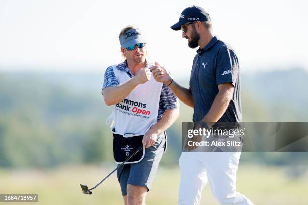 Tom Whitney of the United States fist bumps his caddie after putting for par on the seventh green during the first round of the Simmons Bank Open for...