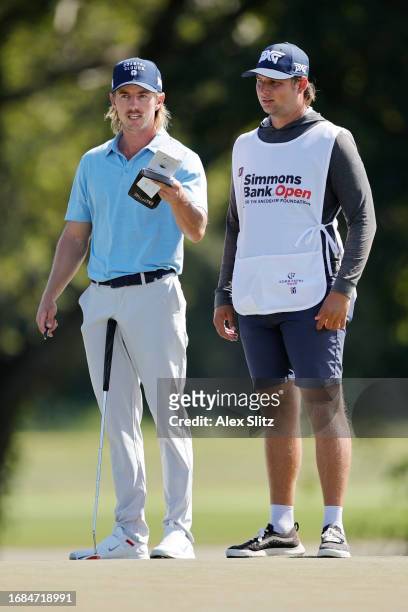 Jake Knapp of the United States stands with his caddie before putting on the seventh green during the first round of the Simmons Bank Open for the...