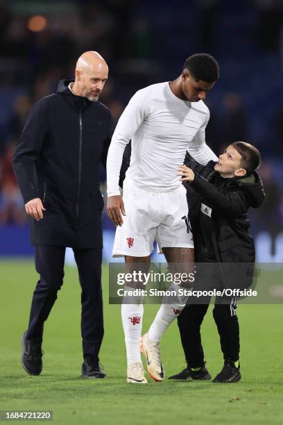 Young boy runs on to hug Marcus Rashford of Manchester United as Manchester United manager Erik ten Hag looks on after the Premier League match...