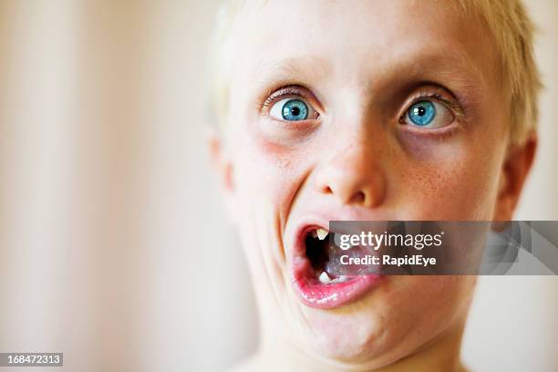 cute blond 8 year old boy makes zany face - ugly face 個照片及圖片檔