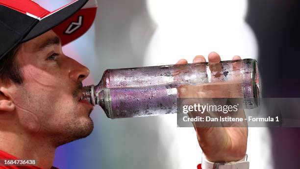 Third placed qualifier Charles Leclerc of Monaco and Ferrari takes a drink in parc ferme during qualifying ahead of the F1 Grand Prix of Singapore at...