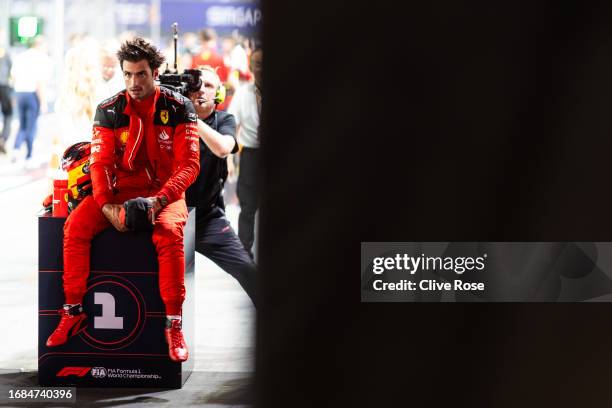 Pole position qualifier Carlos Sainz of Spain and Ferrari looks on in parc ferme during qualifying ahead of the F1 Grand Prix of Singapore at Marina...