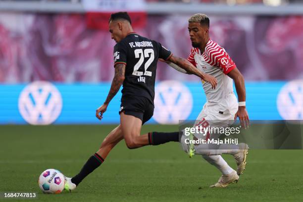 Iago of FC Augsburg is challenged by Benjamin Henrichs of RB Leipzig during the Bundesliga match between RB Leipzig and FC Augsburg at Red Bull Arena...