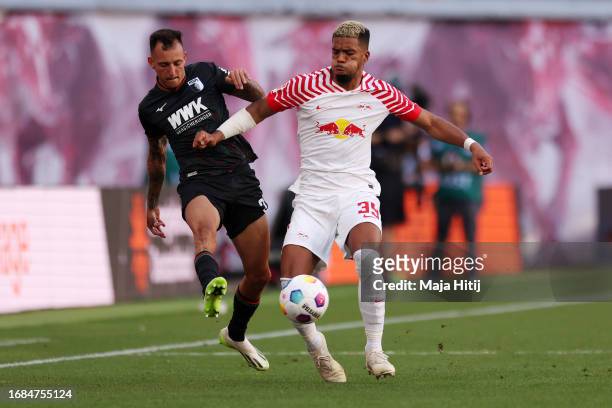 Benjamin Henrichs of RB Leipzig is challenged by Iago of FC Augsburg during the Bundesliga match between RB Leipzig and FC Augsburg at Red Bull Arena...