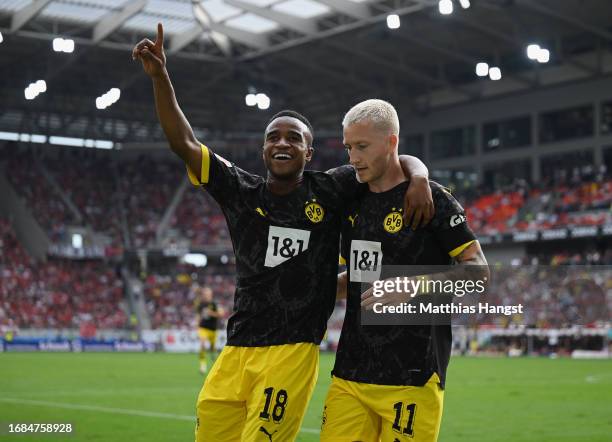Marco Reus of Borussia Dortmund celebrates with teammate Youssoufa Moukoko of Borussia Dortmund after scoring the team's fourth goal during the...