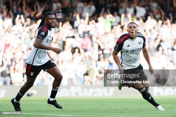 Carlos Vinicius of Fulham celebrates scoring his sides opening goal during the Premier League match between Fulham FC and Luton Town at Craven...