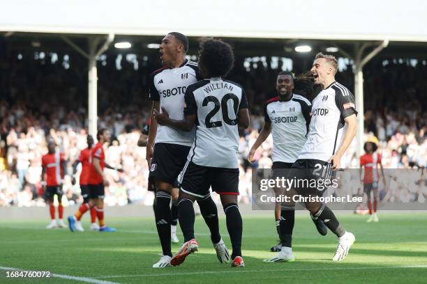 Carlos Vinicius of Fulham celebrates with Willian and Timothy Castagne after scoring his sides opening goal during the Premier League match between...