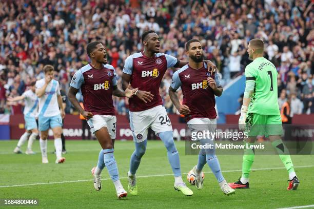 Douglas Luiz of Aston Villa celebrates with teammates Jhon Duran and Leon Bailey after scoring the team's second goal from the penalty spot during...