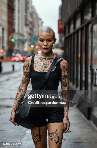 Street portrait of a young, beautiful bald woman with many tattoos Street portrait of a young, beautiful bald woman with many tattoos