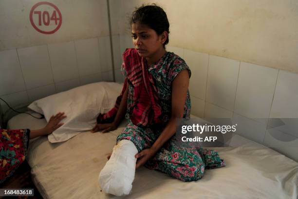 Young Bangladeshi garment worker who was rescued from the Rana Plaza garment building that collapsed sits on a hospital bed with an amputated leg, in...