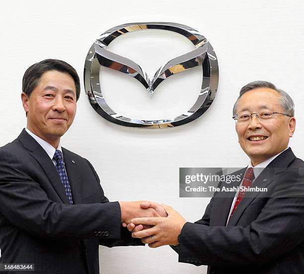 Mazda Motor Co incoming president and CEO Masamichi Kogai and president Takashi Yamanouchi shake hands during a press conference on May 9, 2013 in...