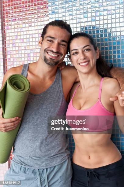 smiling couple standing closely together in gym. - looking closely stock pictures, royalty-free photos & images