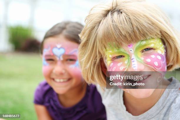 two young smiling girls with their faces painted - school fete stock pictures, royalty-free photos & images