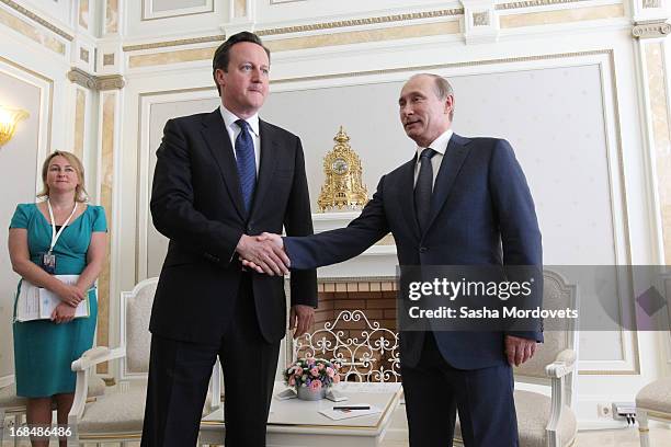 Russian President Vladimir Putin shakes hands as he receives Britain's Prime Minister David Cameron at his Bocharov Rruchey residence on May 10, 2013...