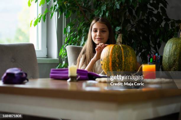 happy girl is cutting pumpkin and is preparing for holiday halloween - 6 11 months stock pictures, royalty-free photos & images