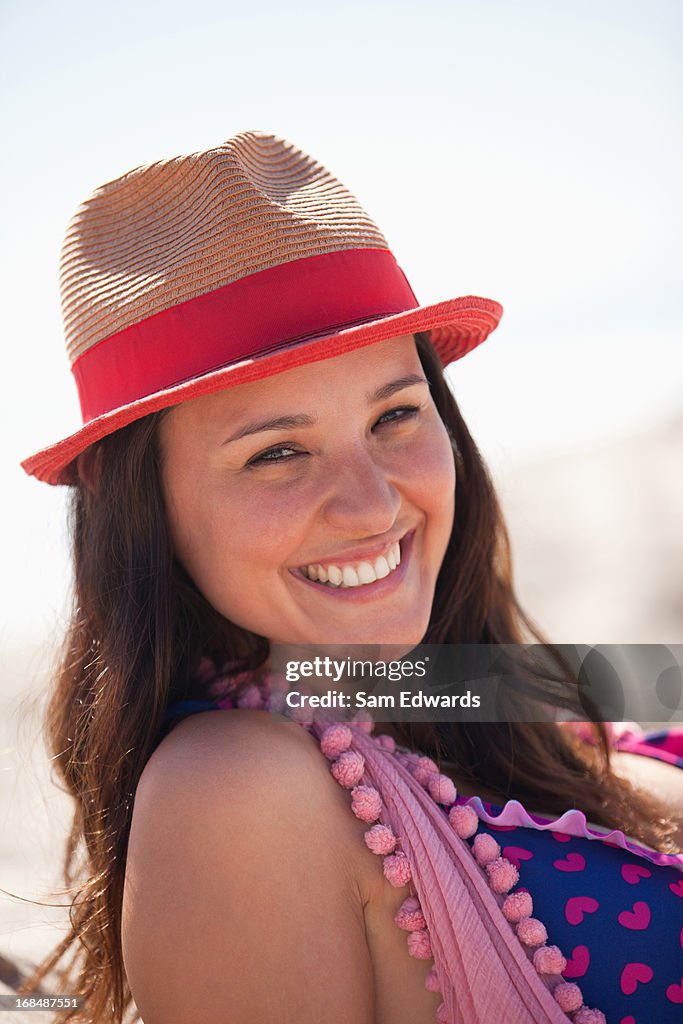 Smiling woman wearing sun hat on beach