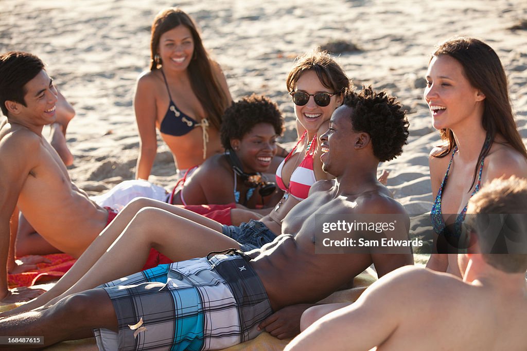 Friends relaxing on beach blanket together