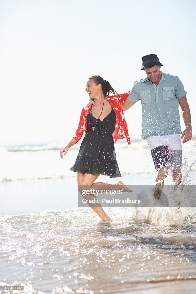 Paar spielt in Wellen am Strand