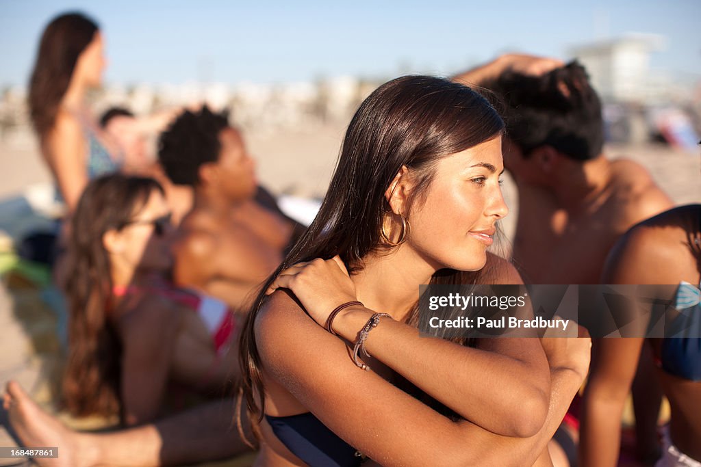 Woman sitting with friends on beach