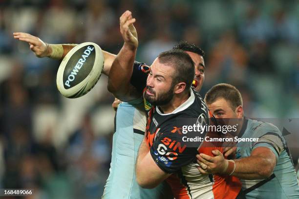 Aaron Woods of the Tigers is tackled during the round nine NRL match between the Wests Tigers and the Cronulla Sharks at Allianz Stadium on May 10,...