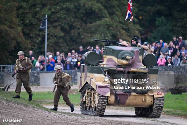 British army re-enactors run past a M3A1 Stuart 'Honey' Tank during a display, on September 16, 2023 in Bovington, Dorset. The Tank Museum's Tiger...