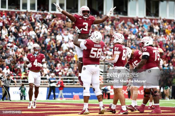 Trey Benson of the Florida State Seminoles celebrates with Bless Harris after scoring a touchdown against the Boston College Eagles during the first...