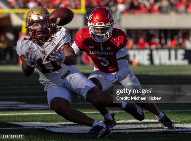 Lewis Bond of the Boston College Eagles attempts to catch the ball that would fall incomplete as Quincy Riley of the Louisville Cardinals defends at...