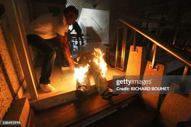 Man lies as he is engulfed in flames after he set himself on fire on May 10, 2013 at the Champ-Fleuri courthouse in the Saint-Denis de la Reunion, on...